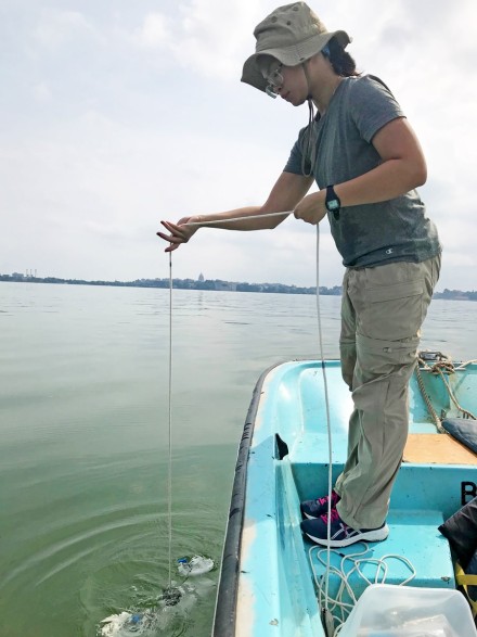 Photo of graduate student Patricia Tran sampling water on Lake Mendota. 