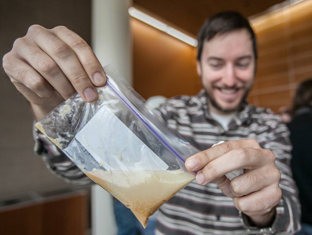 Learner holding a ziplock bag with a fermentation experiment inside.