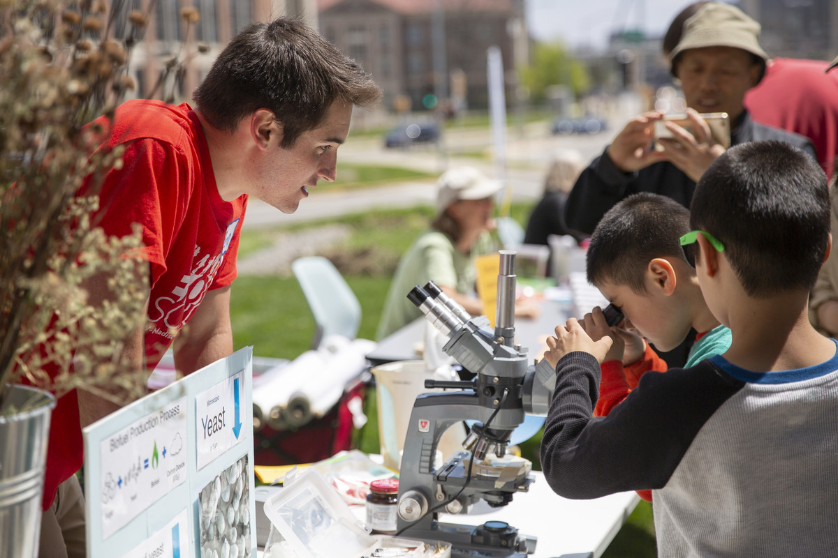 Visitors look at yeast under a microscope