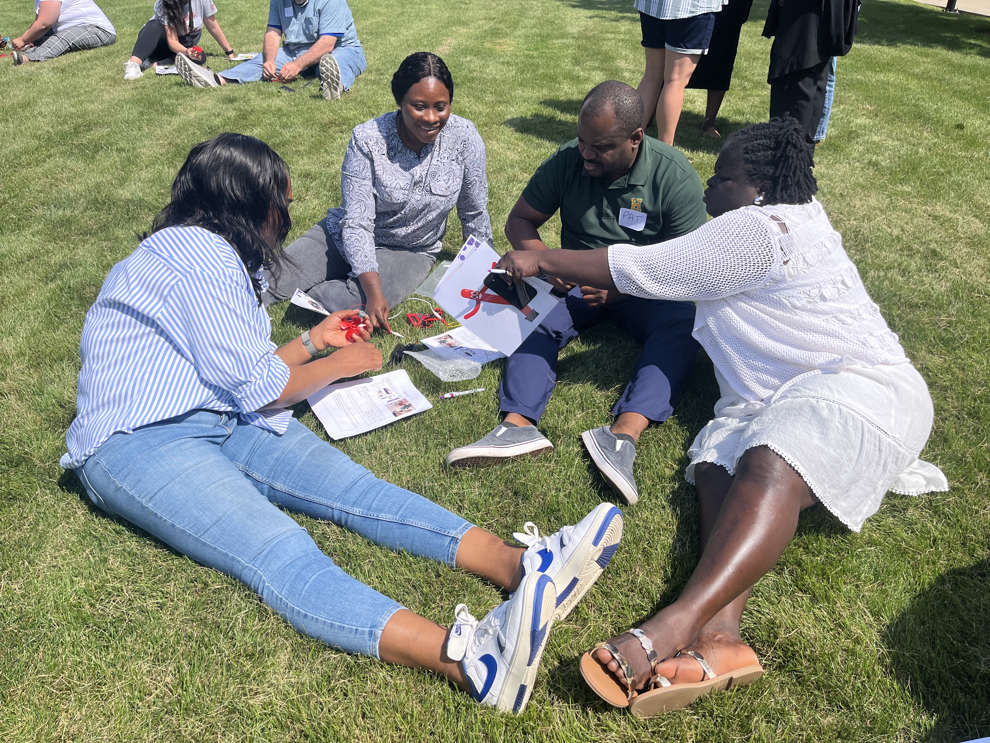 Educators sit outside and try to power a motor with a solar panel