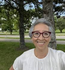 Headshot of Theresa Delgadilla outside with a grin wearing a white shirt