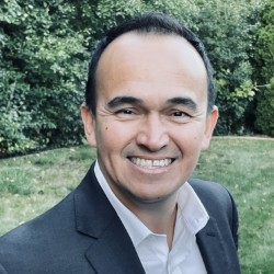 Headshot of Victor Nino smiling wearing a suit