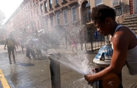 A child plays in the spray of a fire hydrant.