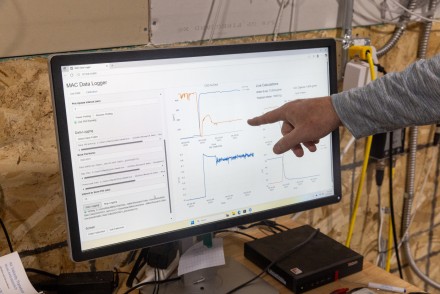 A hand points to a computer screen