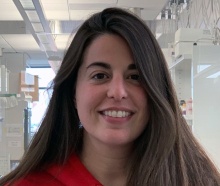 Woman with long brown hair in red sweatshirt