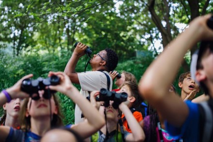 Jason Ward helps children identify birds during a bird walk at Piedmont Park in Atlanta, Georgia.