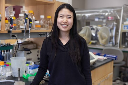woman in black sweater posing for a photo in a biochemistry lab