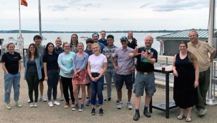 A group of students, staff, and researchers take a group photo together at the memorial union in Madison