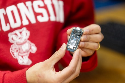 A pair of hands holding a small circuit board