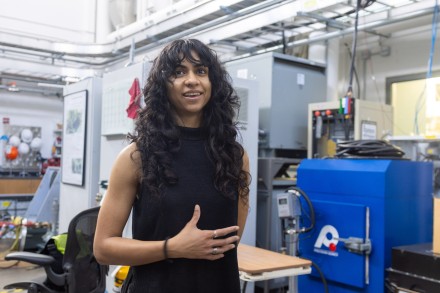 Woman with long black hair gesturing and talking in an electronics laboratory