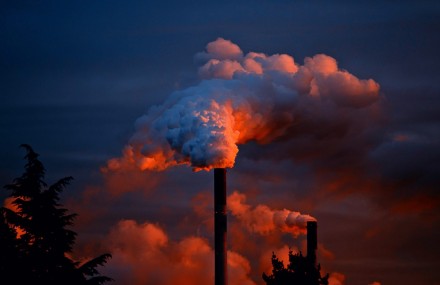 Smoke coming out of a power plant smoke stack at sunset