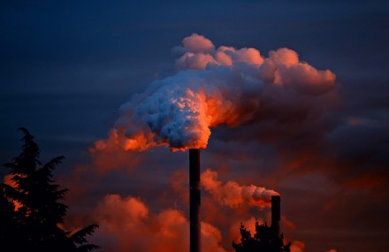 Smoke coming out of a power plant smoke stack at sunset