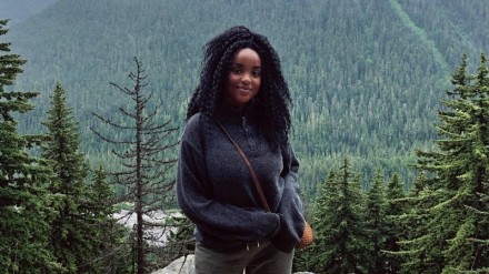 Black environmentalist Wanjiku Gatheru standing in the wilderness