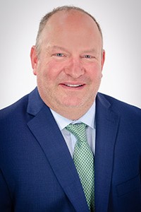 "headshot of Joe Bragger in a suit