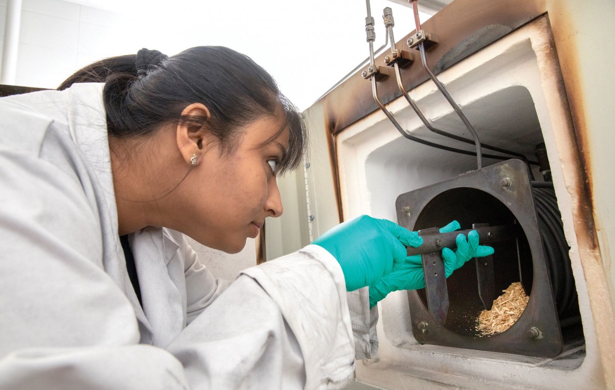Researcher prepares to pyrolize wood chips in lab