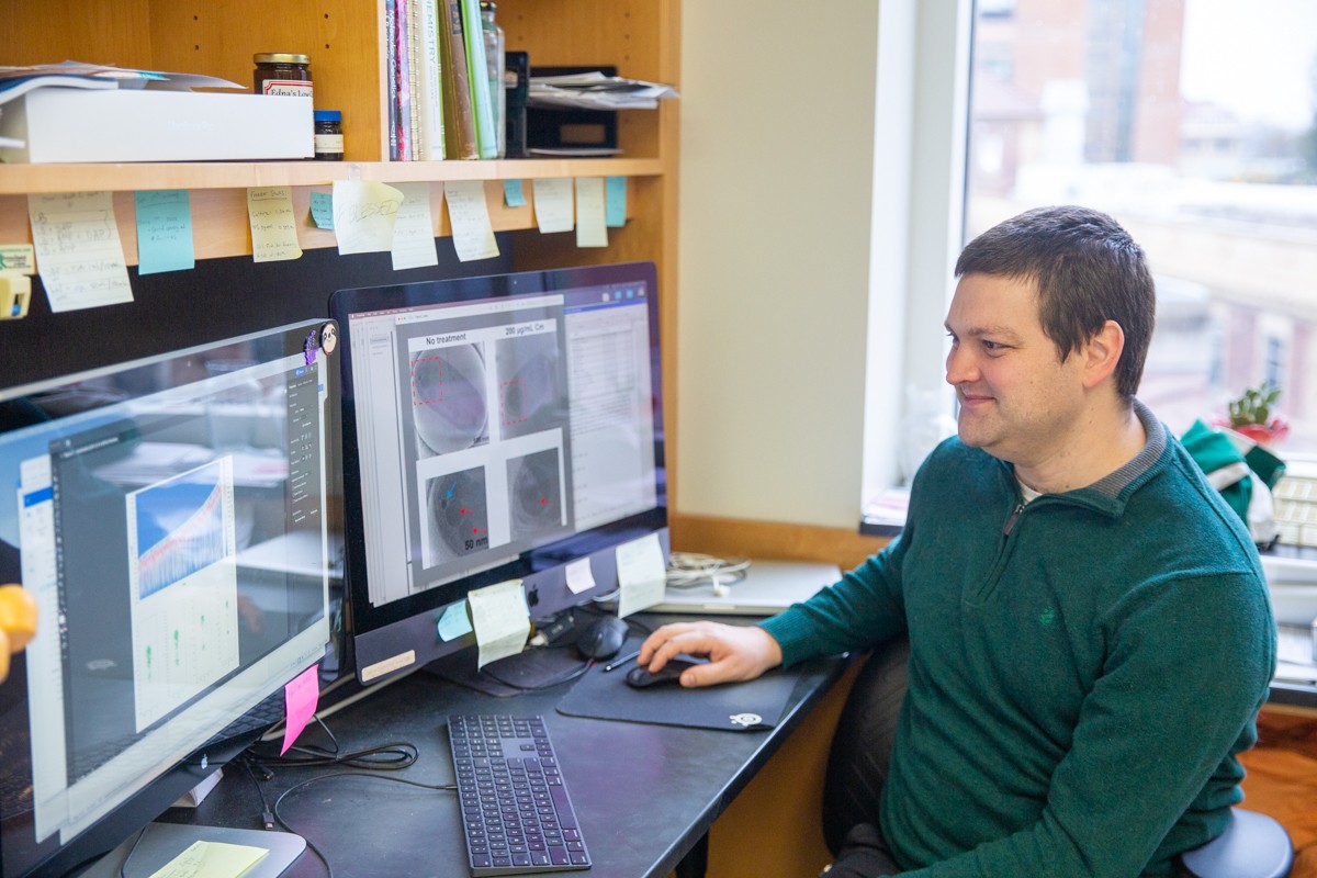 Daniel Parrell sits in front of two computers