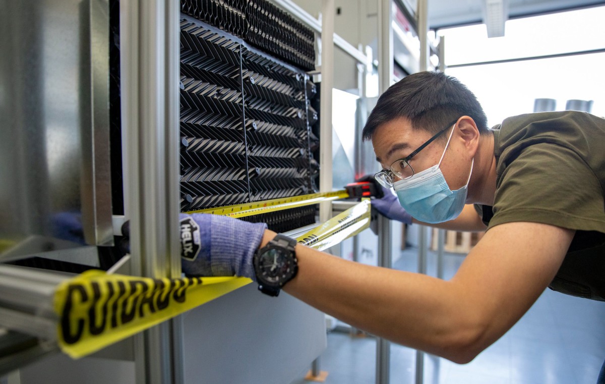 Researcher measuring equipment in lab