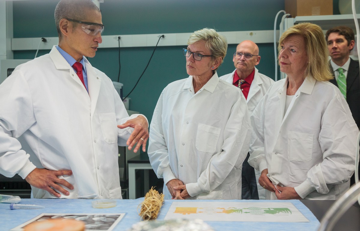 Scientist talks to officials in lab