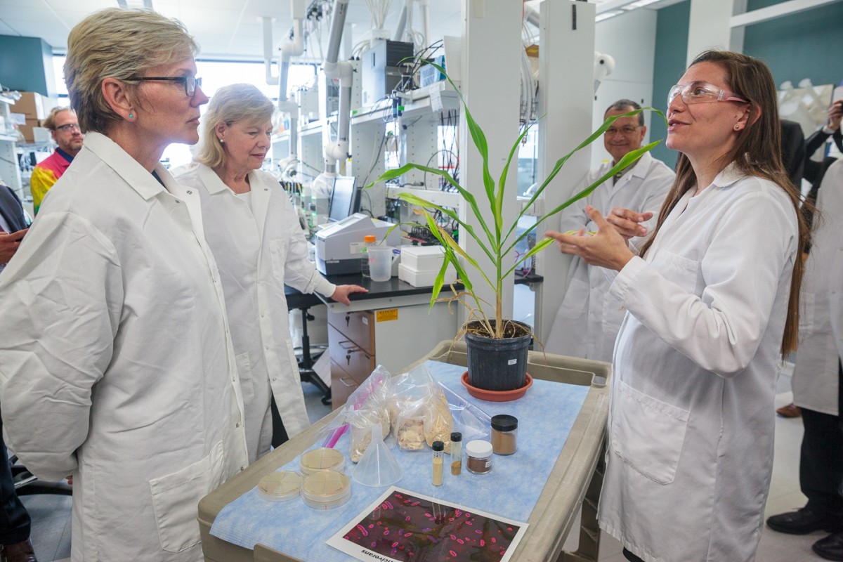 Researcher talks to officials in lab