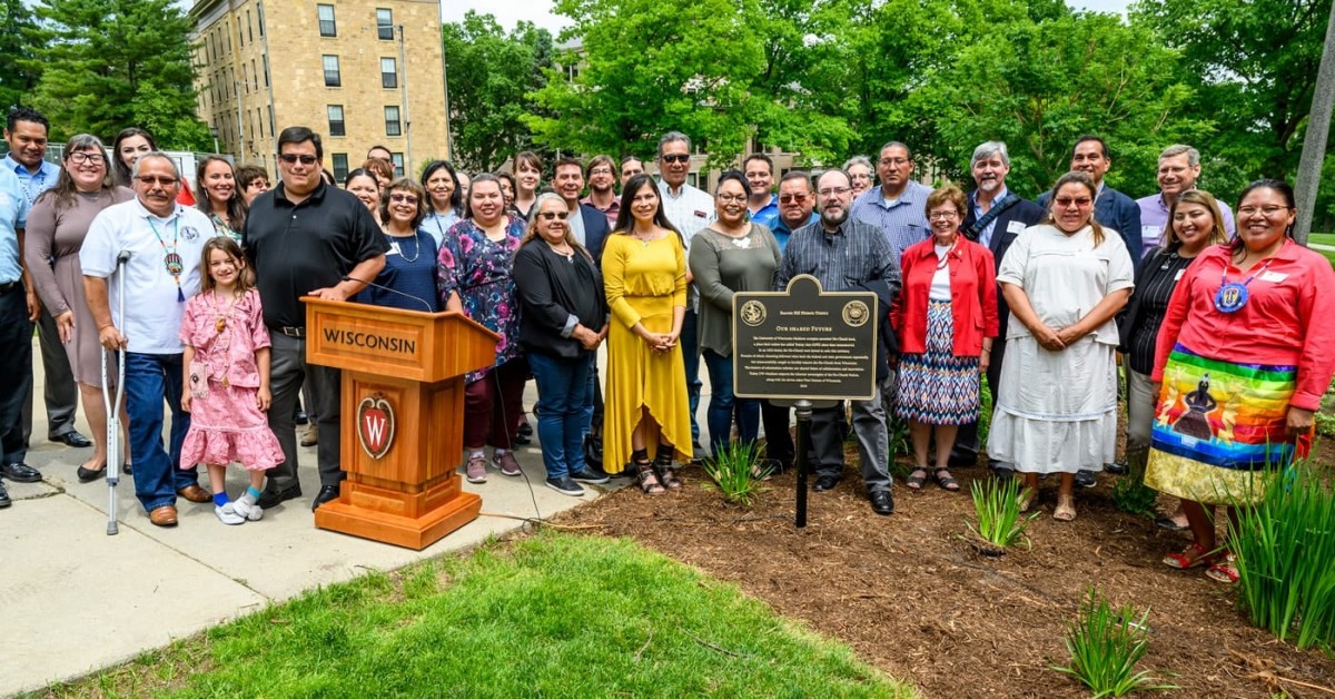 Members of the Ho-Chunk Nation stading outside around a plaque