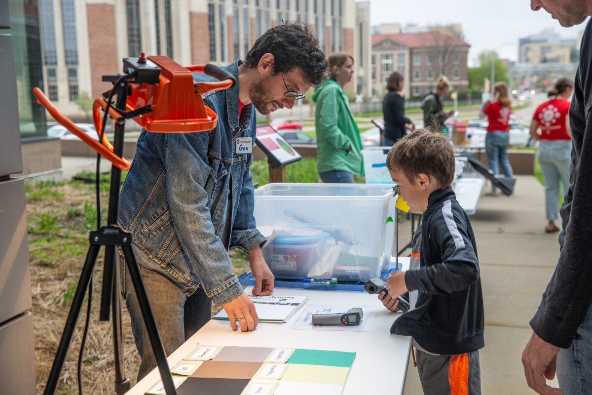 Kid talk to volunteer at table with light