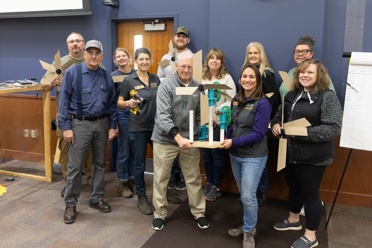 Educators pose for a photo during a previous KidWind Workshop, showing off their turbines.