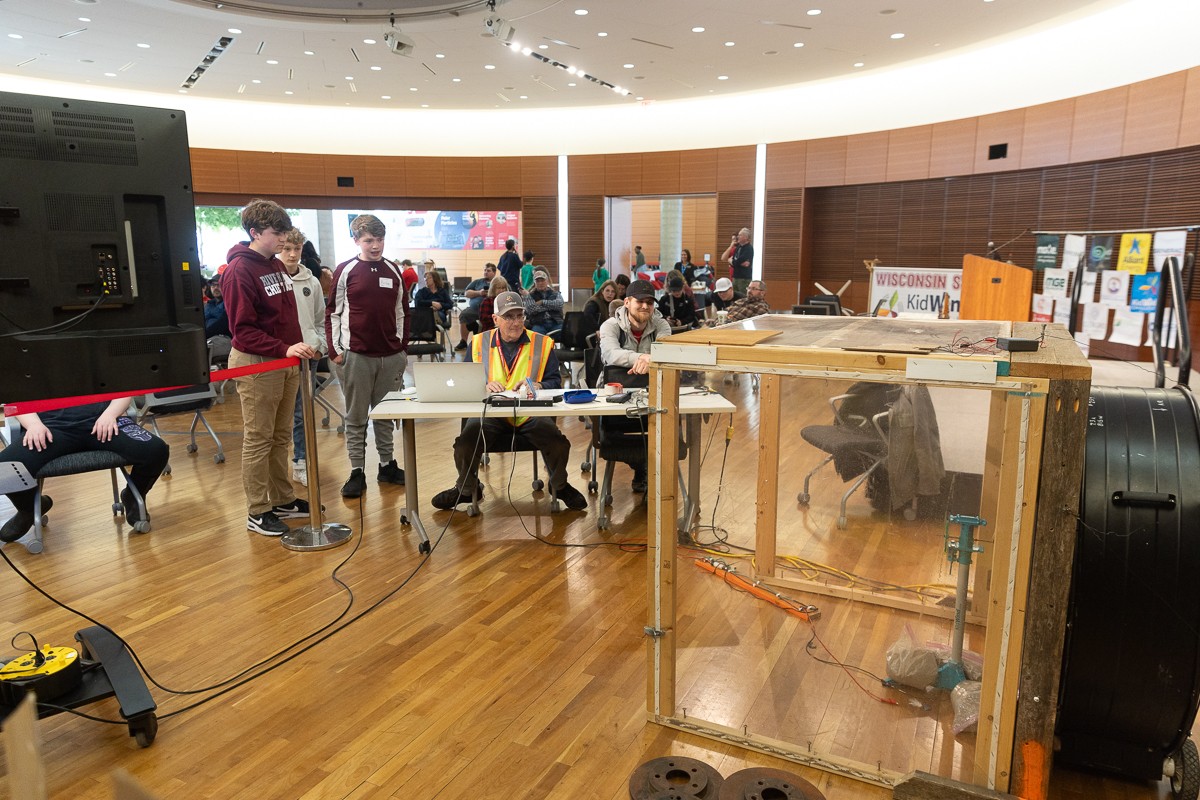 Students watch as their turbine is tested in a wind tunnel.