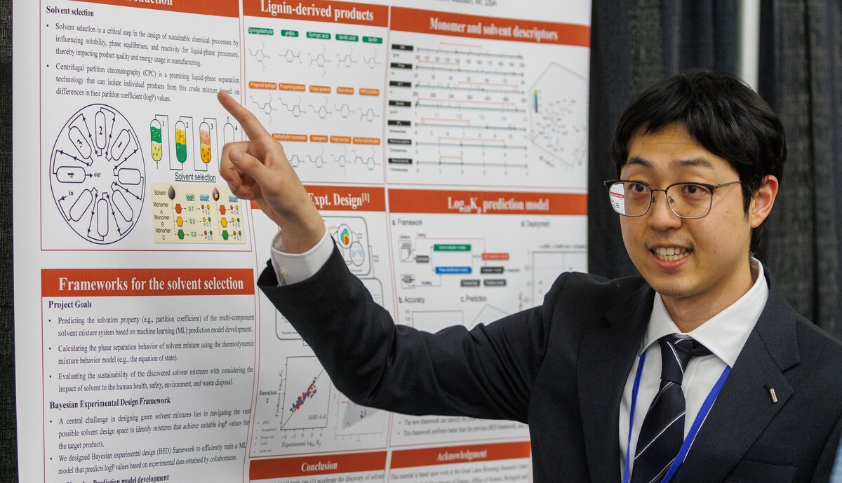 Man gesturing in front of a poster