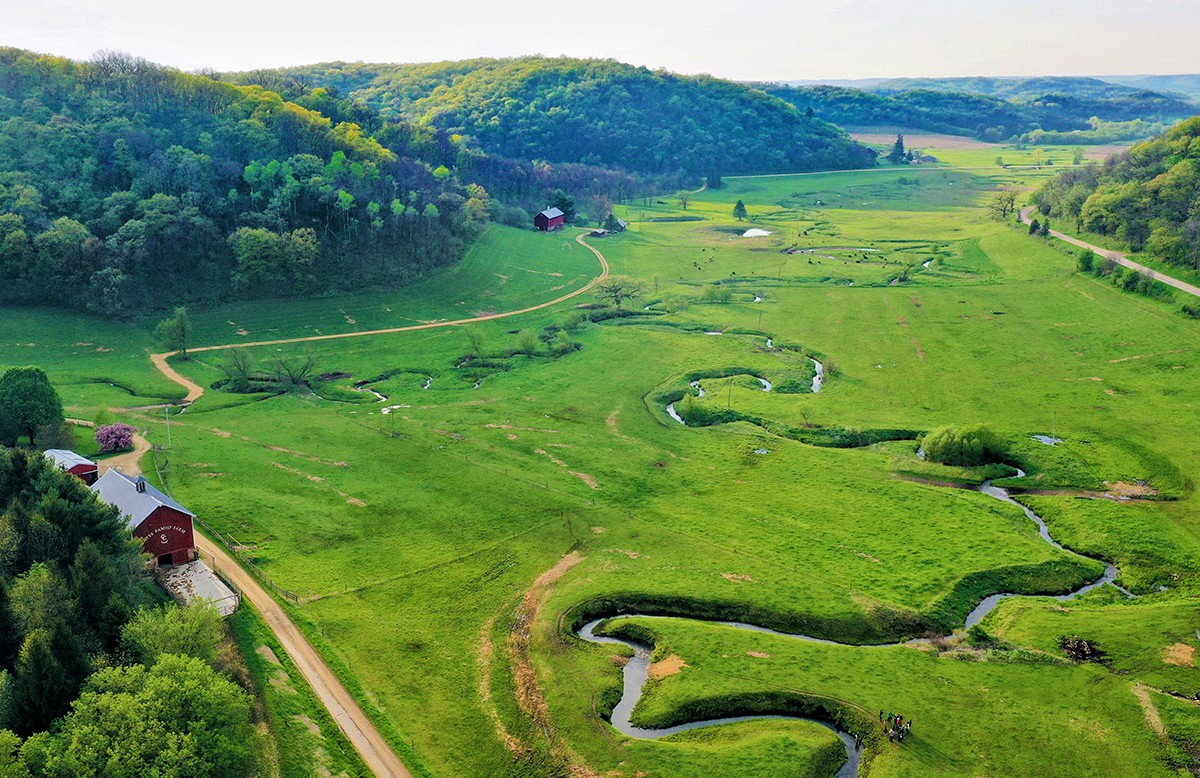 Aerial photo of green pasture with winding stream