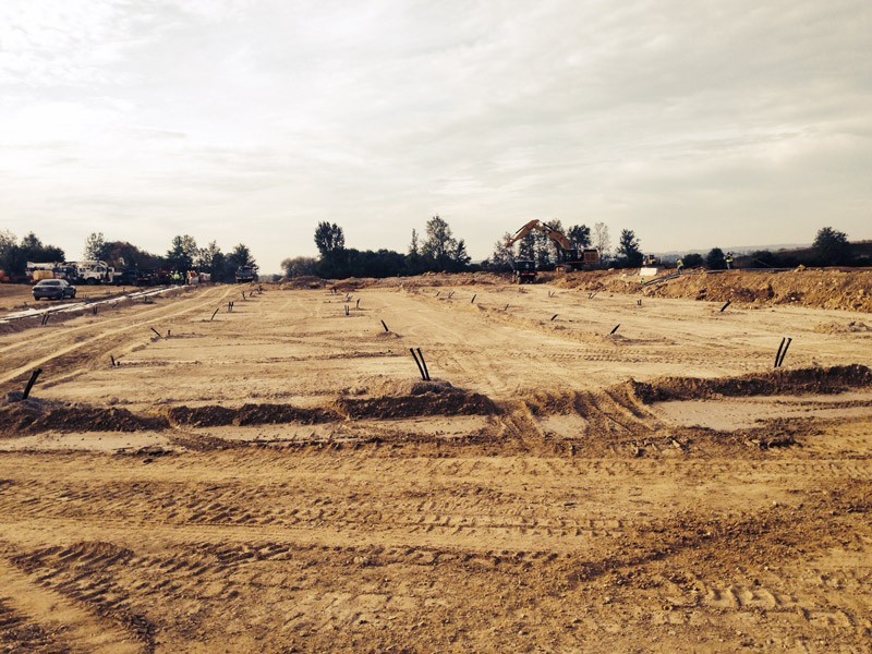 Field with pipe stubs protruding from bare ground