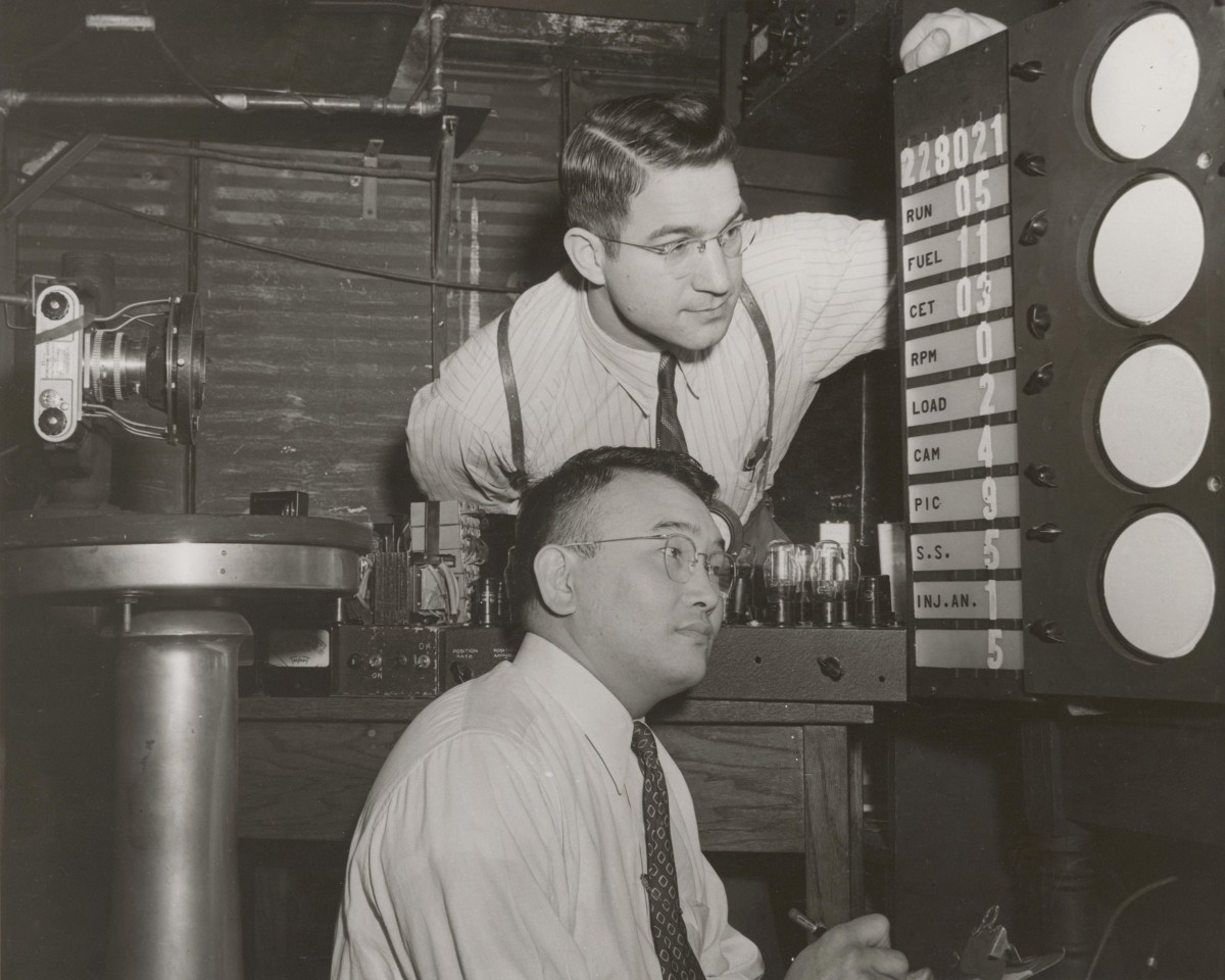 Two men look at a piece of equipment