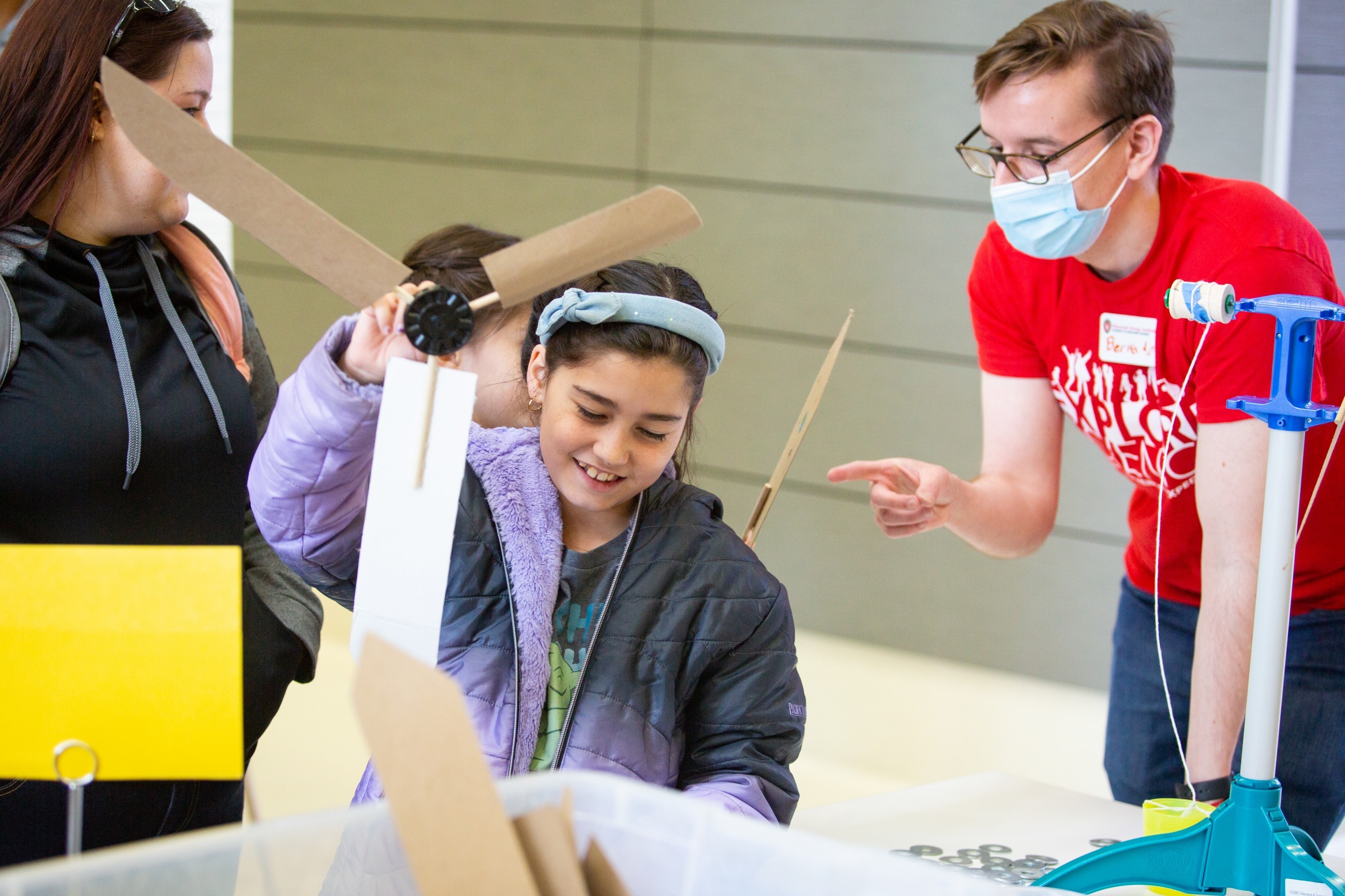 A kid builds and tests a wind turbine blade set.