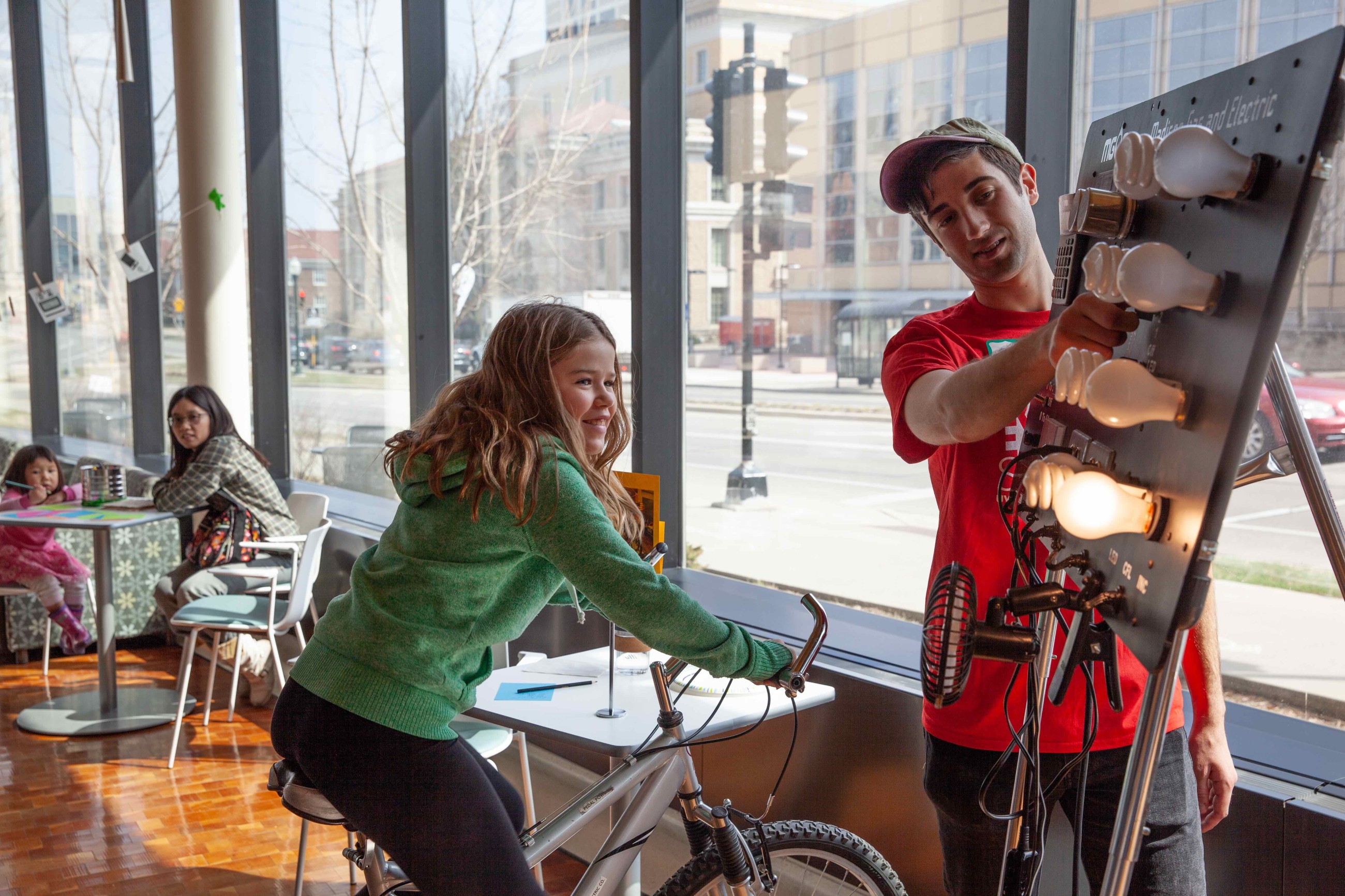 A visitor pedals a bike to see how much power she can provide.