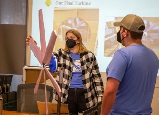 Woman presents model wind turbine