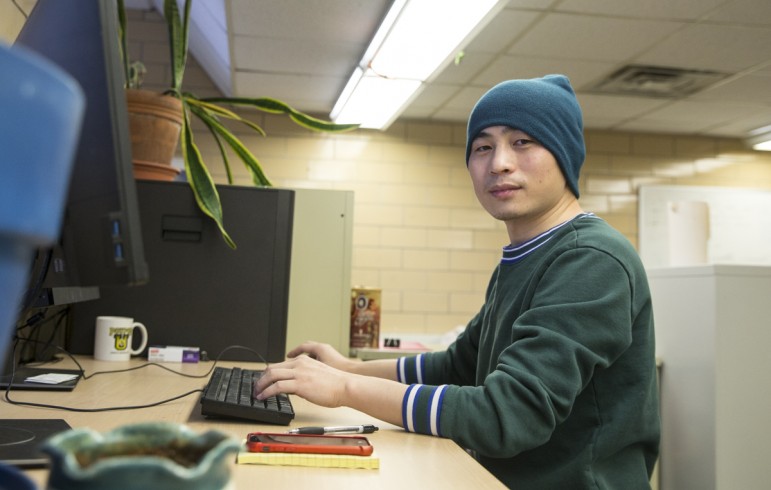 Postdoctoral researcher Xanhua Xie sits in front of a computer at the Wisconsin Energy Institute in Madison, Wis.