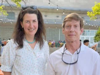 Man and woman smiling for photo in a sunny outdoor location