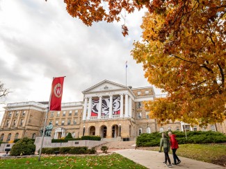 Pedestrians and students walk among the colors of the fall leaves near Bascom Hall at the University of Wisconsin-Madison during autumn on November 11, 2021.