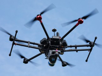 The M600 drone used by Zhou Zhang’s Digital Agriculture Lab flies over an alfalfa field at Arlington Agricultural Research Station