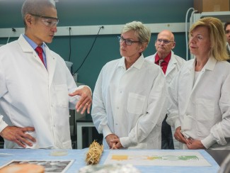Scientist talks to officials in lab