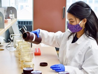 Photo of graduate student Patricia Tran performing an experiment for her research. 