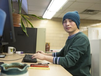 Postdoctoral researcher Xanhua Xie sits in front of a computer at the Wisconsin Energy Institute in Madison, Wis.