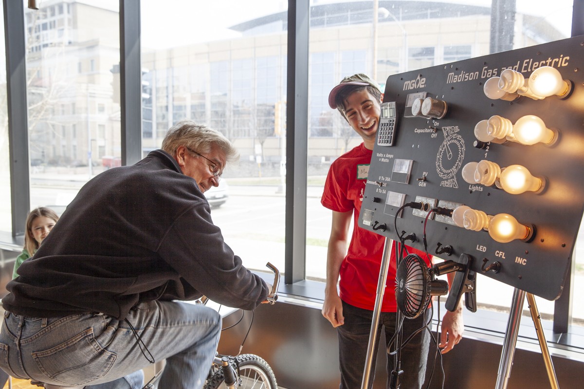 Participants pedals a bike to see how many lightbulbs they can power.