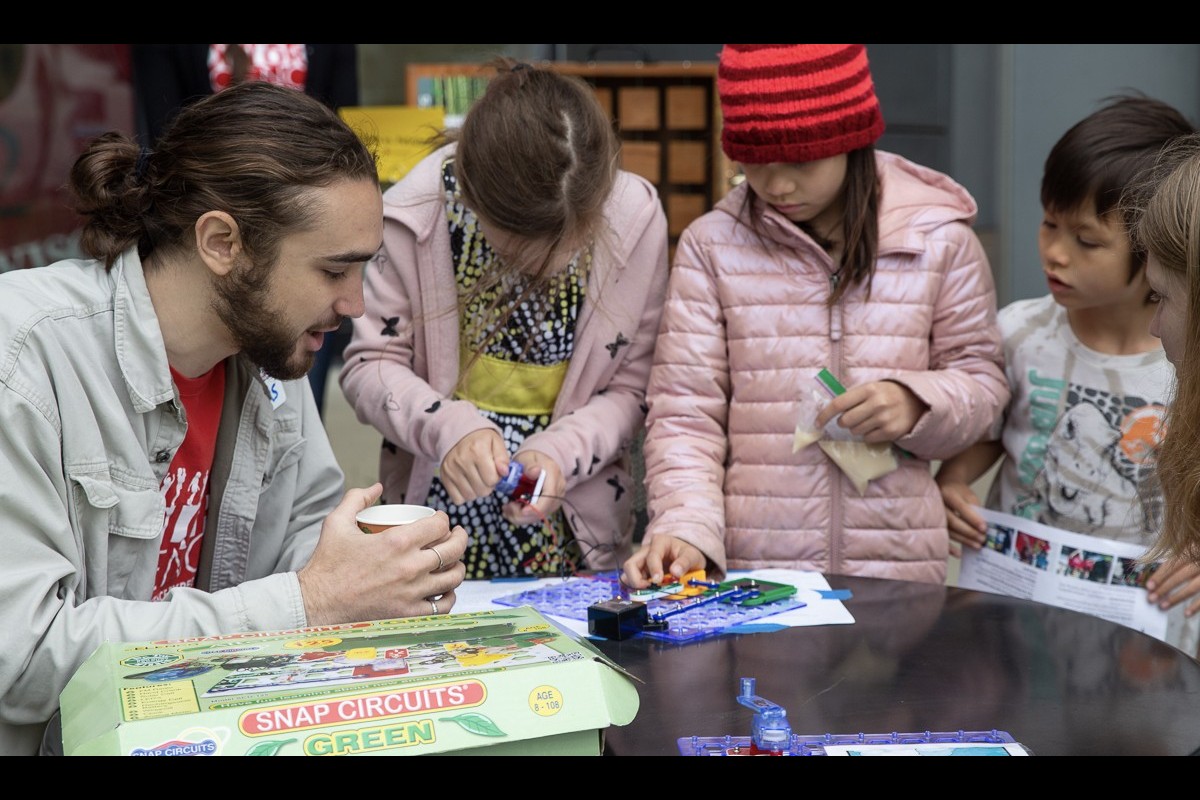 Children gather around a table to build a solar powered circuit at Family Gardening Day 2023..