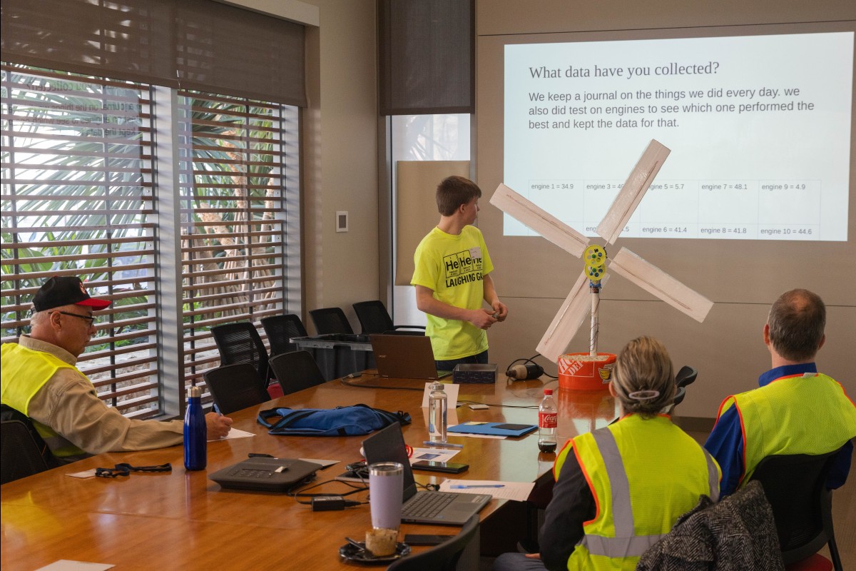 A KidWind team presents their data to the judges.