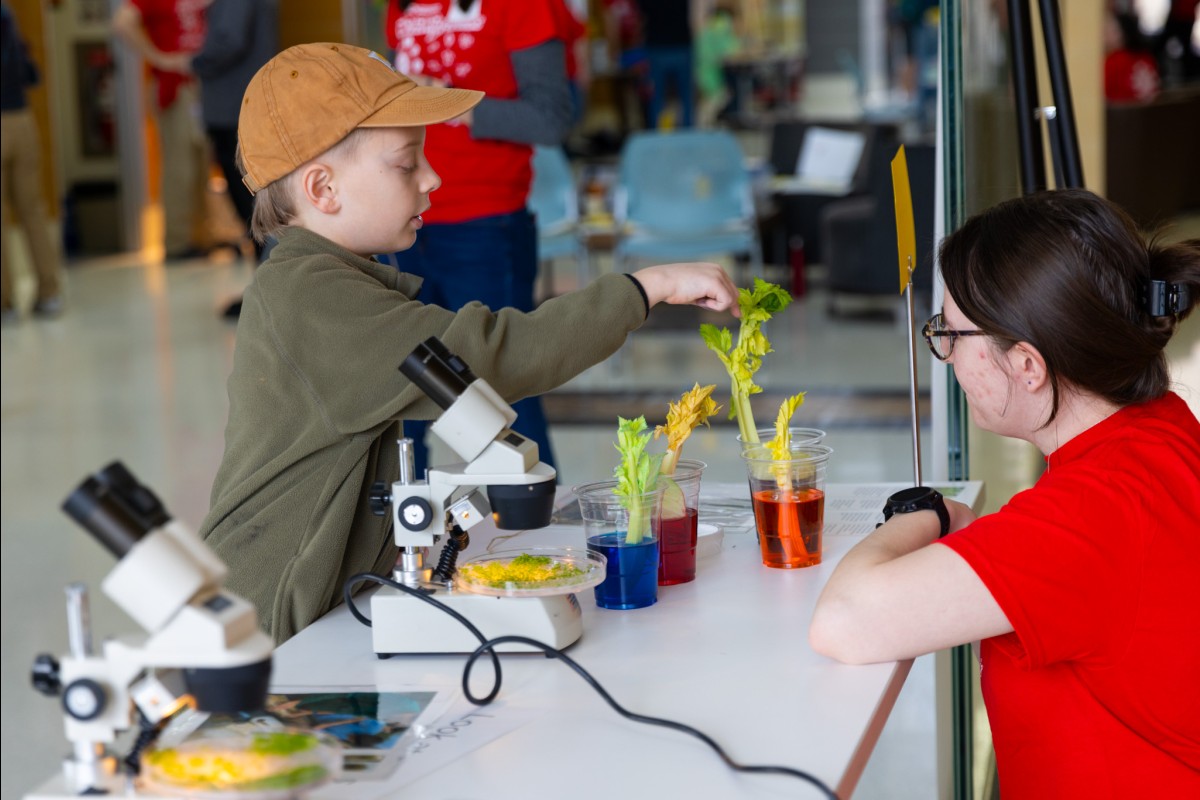 A young visitor examines the results of a experiment with a scientist.