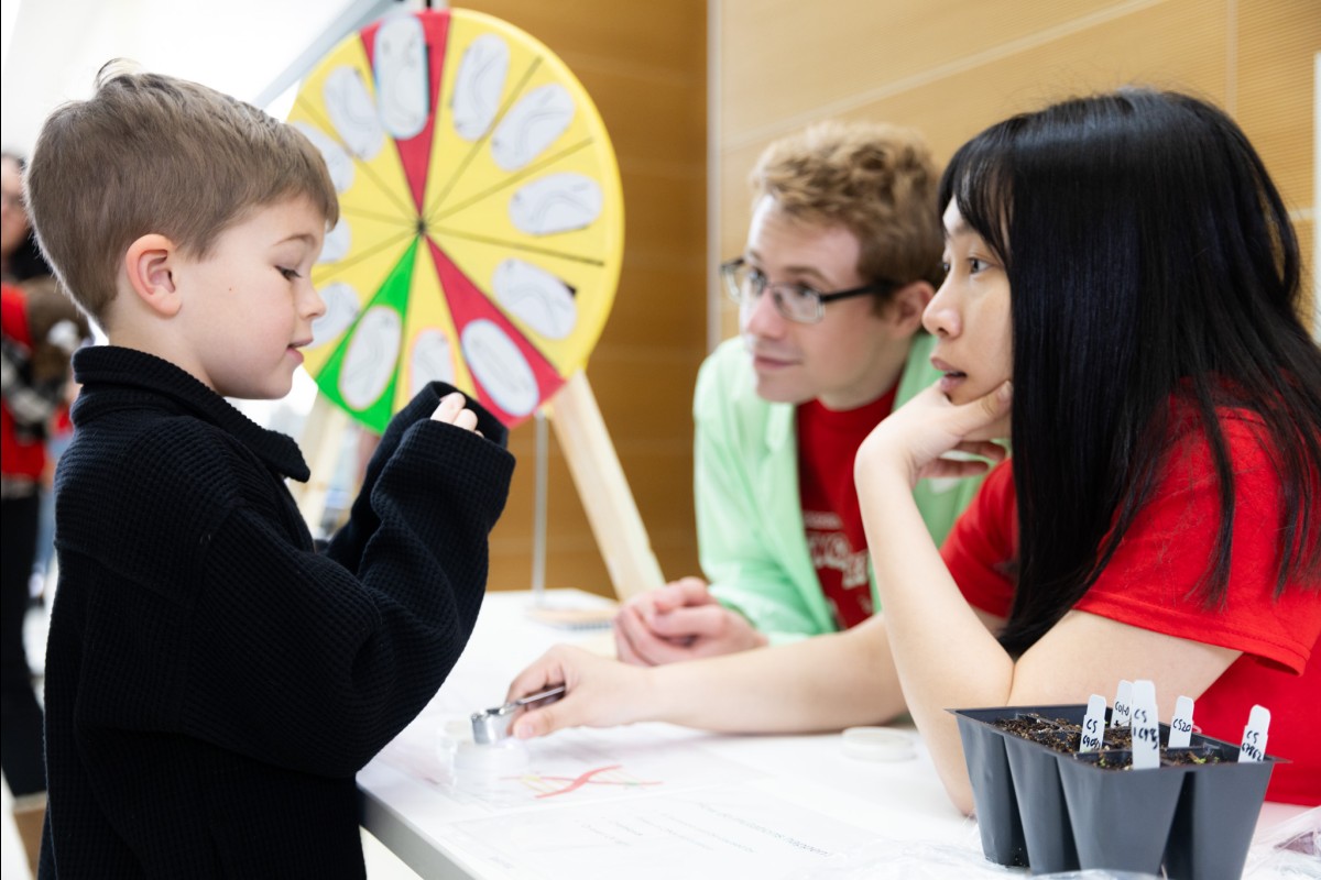 A young visitor talks with two UW Scientists.