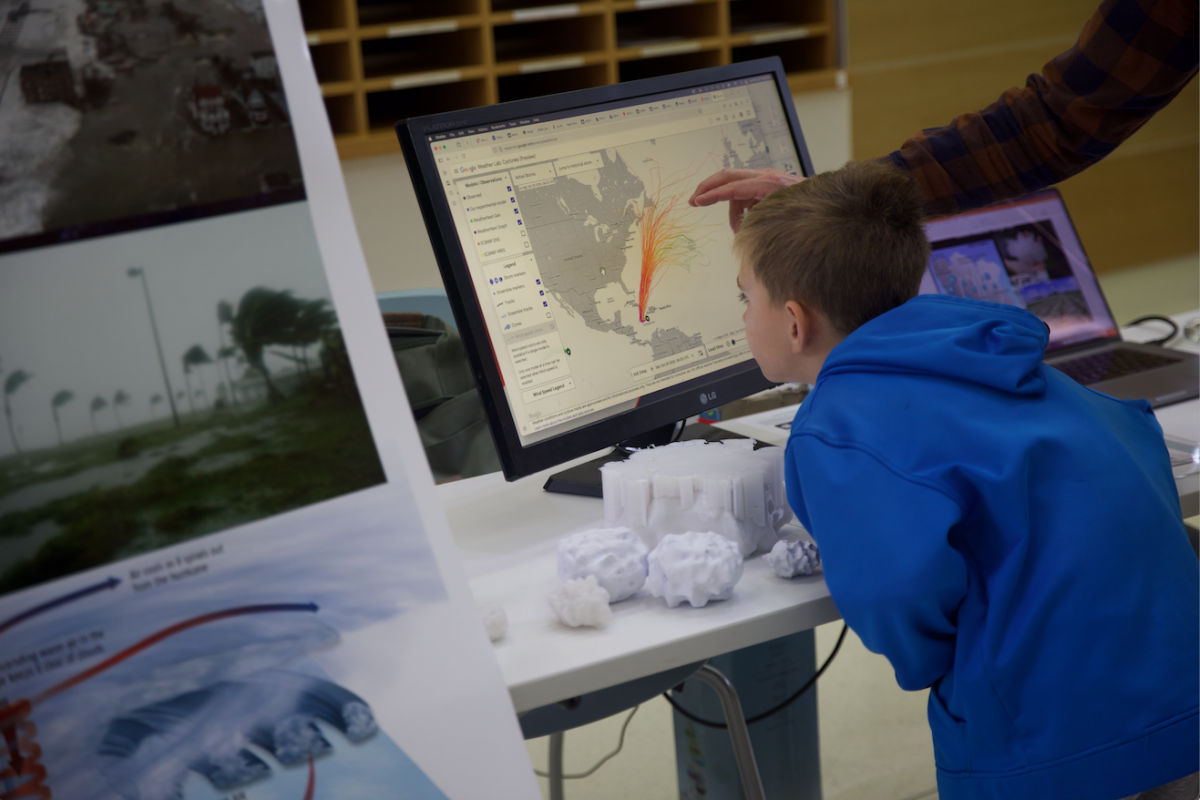 A student examines a map on a computer showing cyclone paths.